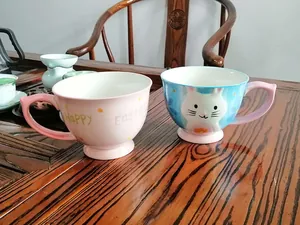 Close-up of ceramic Christmas deer and Happy Easter mugs with hand-painted details