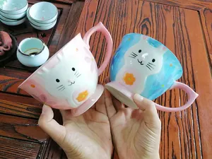 Close-up of 3D relief animal cat and rabbit face patterns on ceramic mugs