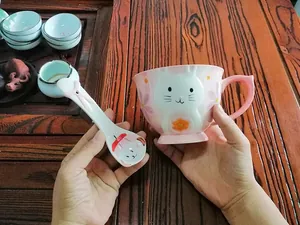 Close-up of ceramic bunny mug with matching spoon featuring 3D rabbit face and floral art