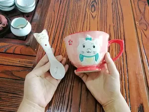 Close-up of pink ceramic Marie cat mug with 3D embossed design and matching spoon