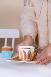 Détail de la tasse en céramique avec plume et anse aile d'ange dorée