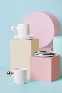 Close-up of minimalist ceramic coffee mug set with metallic handle and pearl glaze finish