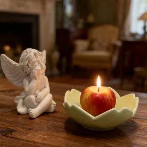 Cozy home decor set with realistic apple candle and lotus ceramic plate on wooden table