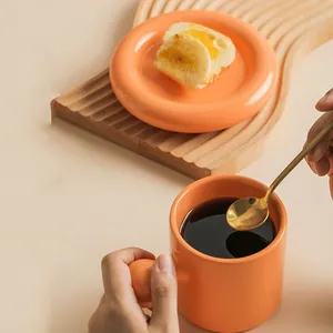 Creative orange ceramic mug and saucer set with round handle and golden spoon
