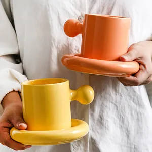 Creative ceramic coffee cup set with ball handle and ring saucer in yellow and orange