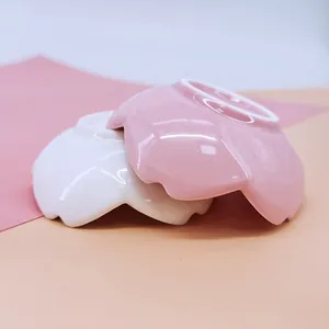 Set of two flower-shaped ceramic sauce bowls in pink and white with smooth glazed finish