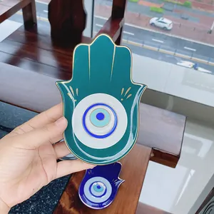 Dettaglio vassoio portagioie Hamsa in ceramica con motivo Evil Eye e bordo dorato