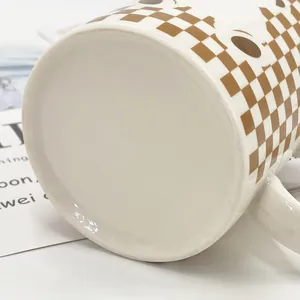 Detailed close-up of a checkered ceramic mug bottom with smooth white glaze finish