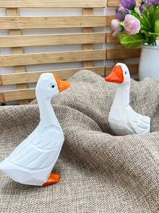 Détails de figurines d'oies blanches facettées sur toile de jute avec fleurs