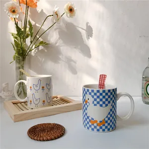 Detail view of white ceramic mugs with duck patterns on a wooden tray with soft sunlight