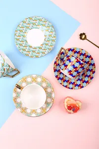 Detail of luxury ceramic coffee cups with geometric prints and gold-plated handles