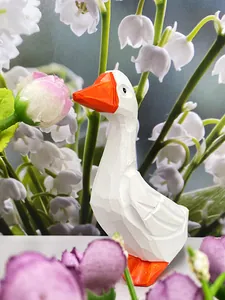 Gros plan d'une figurine d'oie blanche en résine avec texture sculptée et bec orange vif