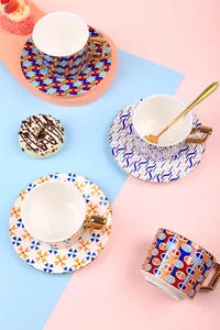 Close-up of luxury ceramic coffee cups with geometric patterns and gold-plated handles