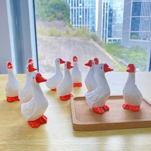 Vue détaillée de neuf figurines de canards en résine sur un plateau décoratif en bois