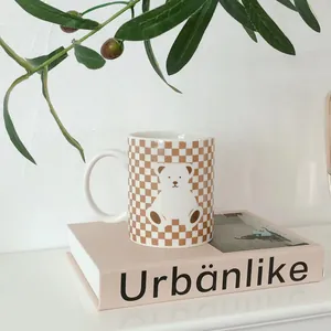 Close-up of ceramic checkerboard mug with cute bear pattern on a decorative book