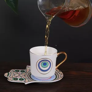 European ceramic coffee cup and Hamsa shaped saucer set with gold trim and patterns