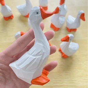 Gros plan d'une figurine de canard blanc sculpté avec un bec orange et un style géométrique