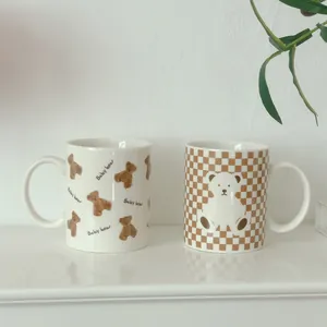 Minimalist ceramic mugs set featuring cute brown baby bear and checkerboard patterns