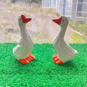 Paire de figurines d'oies blanches minimalistes avec becs orange sur gazon