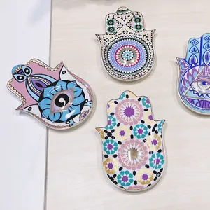 Dettaglio di quattro vassoi Hamsa in ceramica con motivi Evil Eye e bordi dorati