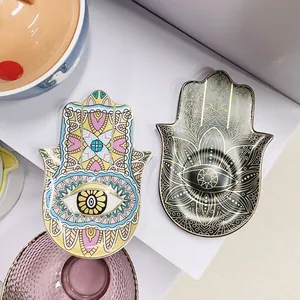 Macro-opname van Hamsa sieradenschalen met handgeschilderde en zwart-gouden mandala-patronen