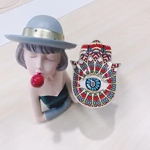 Detail van de Hamsa-hand keramische schaal met mandala-patroon en bubble girl beeldje