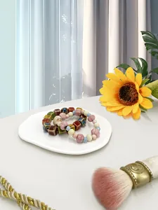 Detail of colorful ceramic beaded bracelets on a decorative irregular jewelry tray