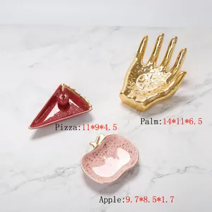 Vista detallada de bandejas de cerámica para joyas en forma de mano, pizza y manzana