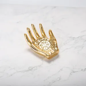 Bandeja de joyería nórdica en forma de mano dorada con relieve mandala sobre mármol