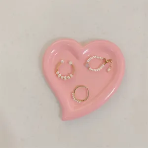 Detailed view of pearl jewelry set arranged in a pink heart-shaped ceramic jewelry tray