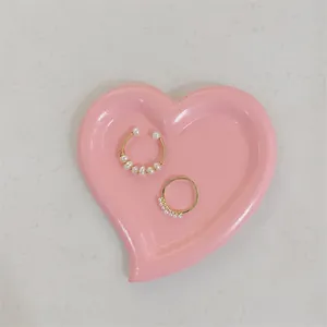 Close-up of pearl jewelry set with ring and ear cuff on a pink heart shaped resin tray