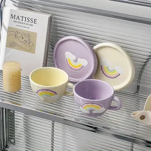 Detail of hand-painted rainbow ceramic coffee mugs with textured cloud relief on a shelf