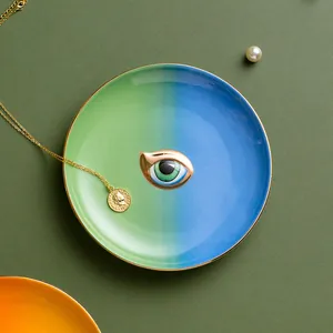 Λεπτομέρεια κεραμικού δίσκου κοσμημάτων evil eye με χρυσό χείλος και μπλε διαβάθμιση