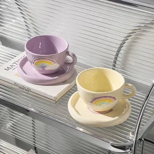 Detail of hand-painted rainbow ceramic coffee cups and saucers in purple and cream yellow