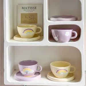 Macro shot of ceramic coffee cup and saucer with rainbow clouds and floral relief