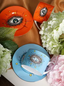 Detailed top view of ceramic evil eye coffee cup and saucer set on soft velvet