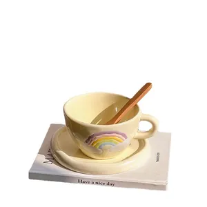 Rainbow relief ceramic coffee cup and saucer set with wooden spoon in creamy yellow