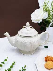 Détail d'une théière en céramique vintage avec reliefs floraux pour le thé de l'après-midi