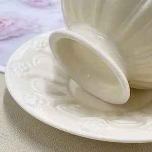 Vue macro détaillée d'une tasse en céramique crème avec relief floral et texture nervurée