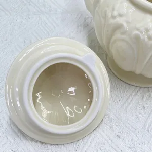 Détail du couvercle de théière en céramique crème avec motif de relief floral européen