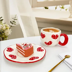 Détail de l'ensemble tasse à café et soucoupe en céramique avec motifs cœurs rouges
