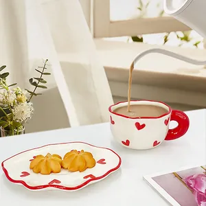 Détail versant du thé au lait dans une tasse en céramique cœur avec soucoupe ondulée