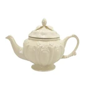 Théière vintage en céramique blanc crème avec reliefs floraux élégants style cour