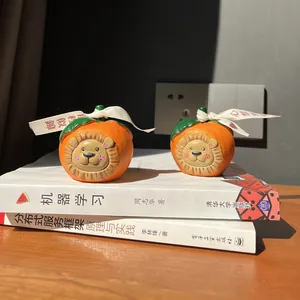 Macro detail of lion-shaped persimmon resin ornaments with white ribbons on books