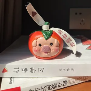 Detailed view of resin pig persimmon figurine with lucky ribbon on a stack of books