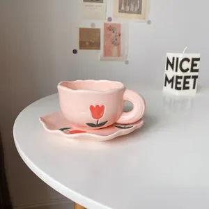 Vue détaillée d'une tasse à café en céramique rose et soucoupe aux motifs de tulipes