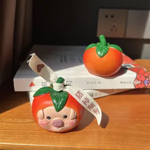Macro detail of cartoon resin persimmon piglet ornament with good luck blessing ribbon