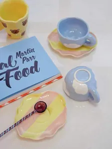 Détail de la tasse en céramique faite main avec sa soucoupe arc-en-ciel ondulée