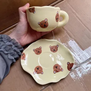 Détail d'une tasse à café en céramique style coréen et soucoupe avec motifs d'ours