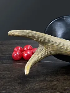 Detailopname van een vintage hertengeweih sierschaal met rode kralen op een houten tafel